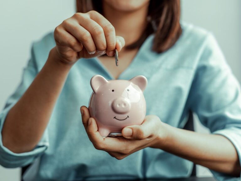 mulher segurando cofre de porquinho