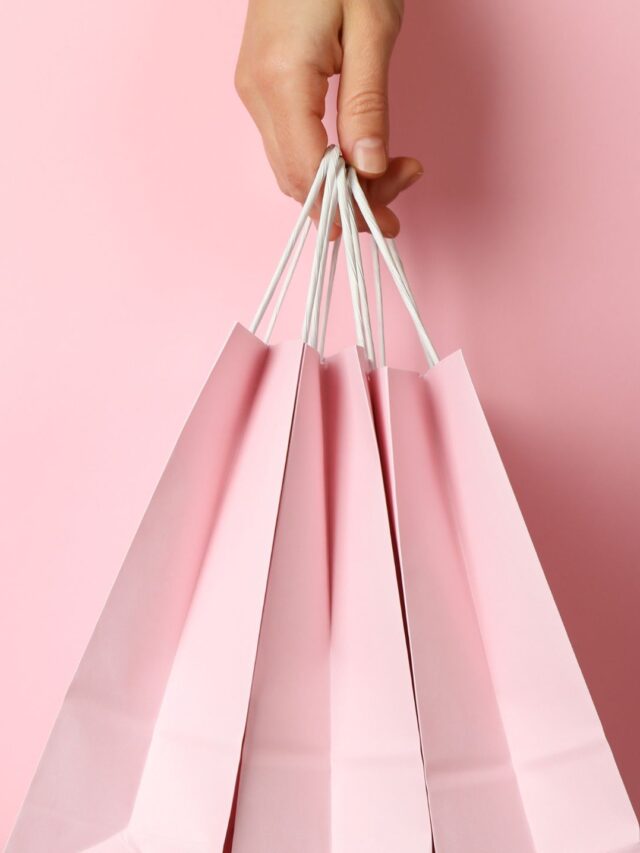 mão segurando sacolas rosa