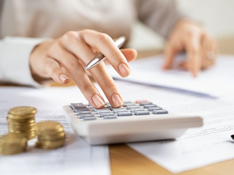 mulher usando calculadora para pagar seus impostos MEI