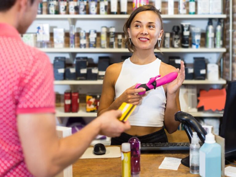 mulher em uma loja com um vibrador na mão para ilustrar um post sobre como abrir uma sex shop