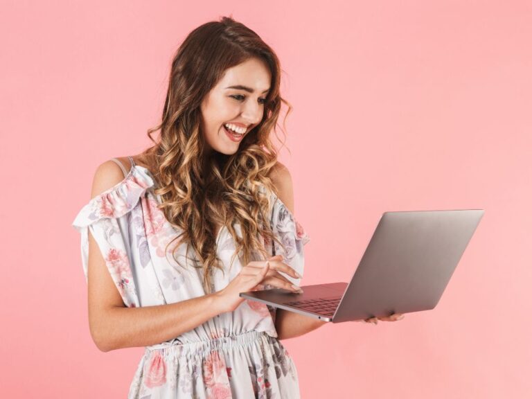 mulher sorrindo com computador na mão aprendendo a montar sex shop online