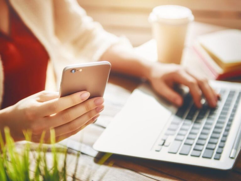 Pessoa usando computador e celular