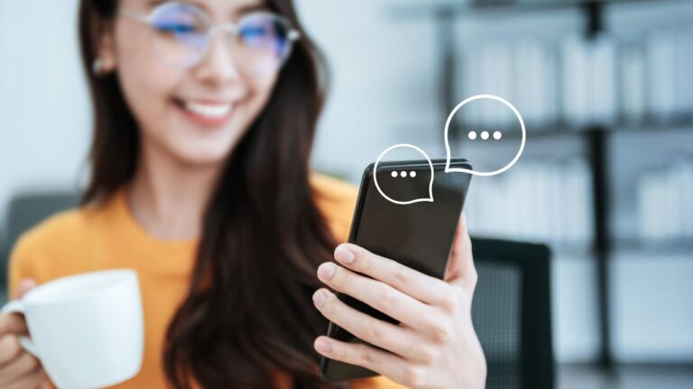 mulher sorrindo com celular na mão usando chatgpt