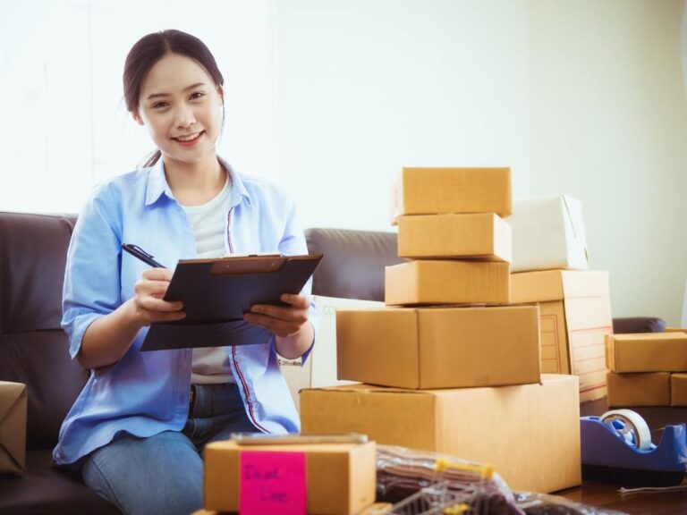 Mulher sorrindo e empacotando pedidos