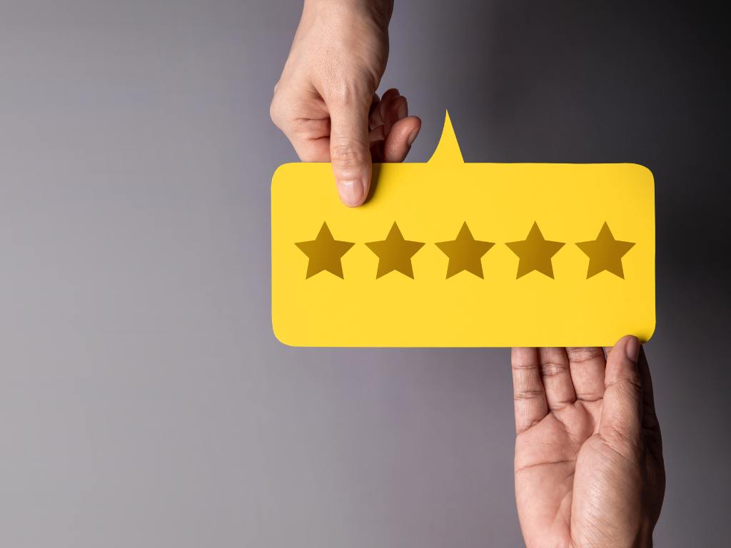 mãos segurando uma imagem de balão com estrelas dentro representando avaliação