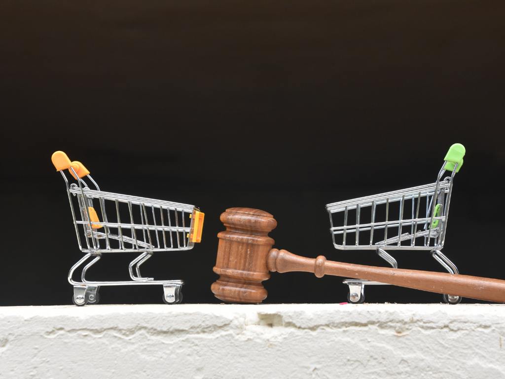 martelinho de juiz no meio de dois carrinhos pequenos de supermercado