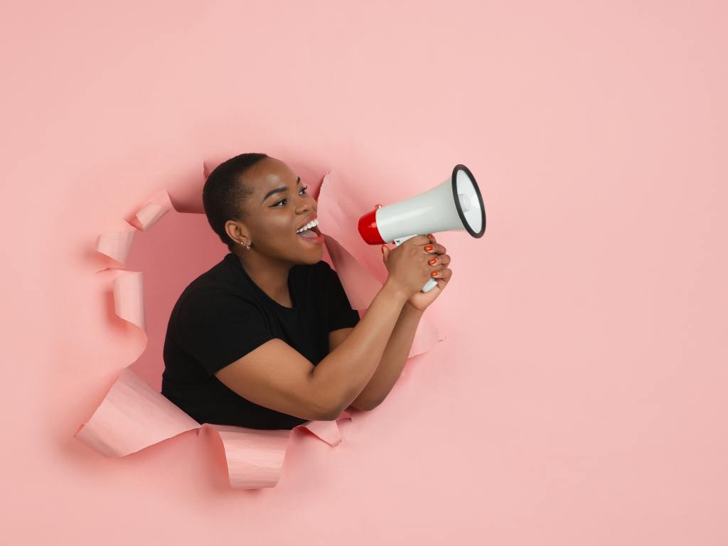 Mulher usando megafone para anunciar