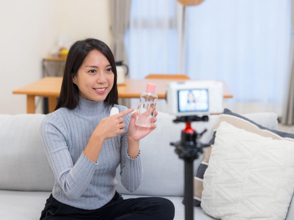 Mulher mostrando produto para câmera