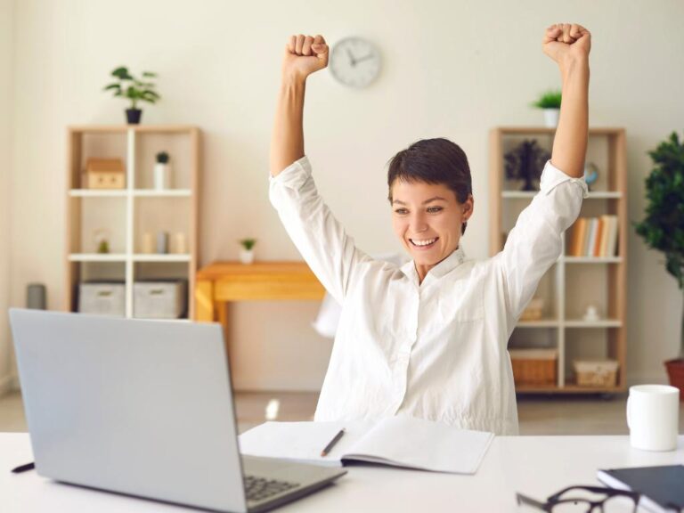 Mulher comemorando olhando seu computador